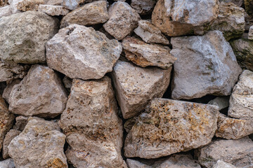 pattern of a stone fence made of brown cobblestones close up