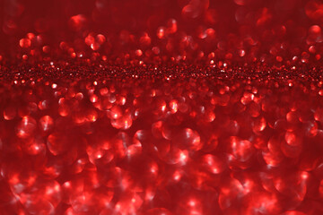 Red glitter bokeh background with sparkling light, abstract defocused texture. Holiday lights.
