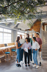 Portrait Of Multi-Cultural Business Team Standing In Modern Open Plan Office Together