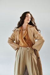 A young woman showcases her fashion flair in an elegant autumn ensemble, radiating confidence in a contemporary studio.