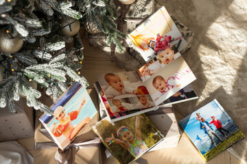 Fototapeta premium Photo printing, Christmas family memories. Small boy looking at Christmas printed photos.