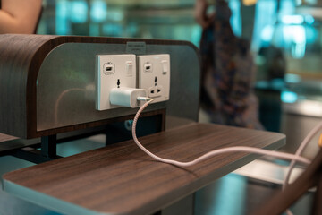 Plug socket or USB port for free charging mobile phone or laptip in the airport terminal service...