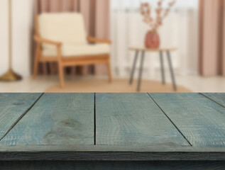 Empty turquoise wooden table near armchair, side table and window with curtains. Space for design