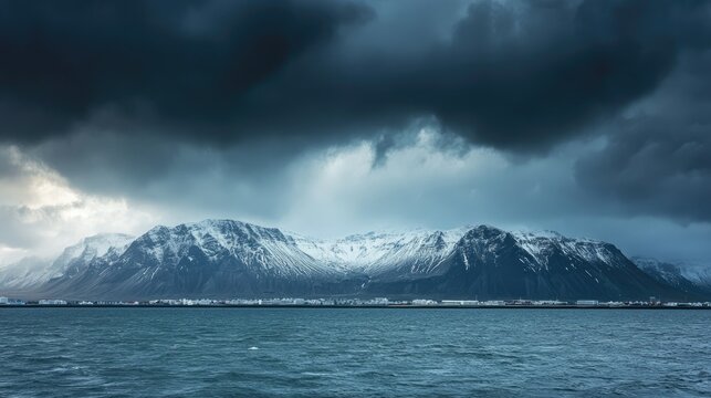 Reykjavik's Esjan mountain range viewed from across the bay with a dramatic sky overhead.