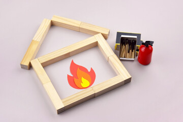 A box of matches placed next to a toy red fire extinguisher against a light background.