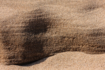 A close-up view of the side of a very small area of the sandy beach in late February at Kohler-Andrae State Park, Sheboygan, Wisconsin