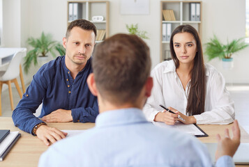 Family couple of clients interacts with a real estate agent or financial consultant during a...