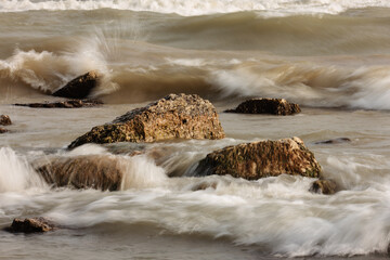 Lake Michigan waves crash over the near on-shore boulders during a windy November day at Harrington...