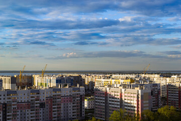 Naklejka premium Top view of the city in the light of the sun under a cloudy sky at sunset
