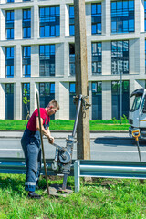 A man in a red shirt is working on a pole