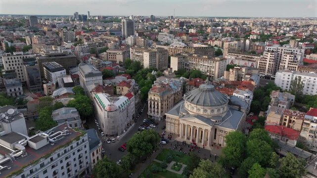 Romanian Atheneum in Bucharest during a summer sunset. Aerial 4k video of this amazing landmark historical building from Bucharest, Romania, on Victoriei Avenue (Calea Victoriei). Travel to Romania.