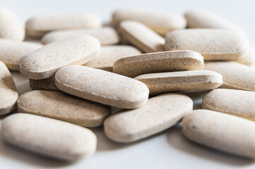 Medical tablets, placed next to each other on a white surface. Therapies, medicines and supplements.