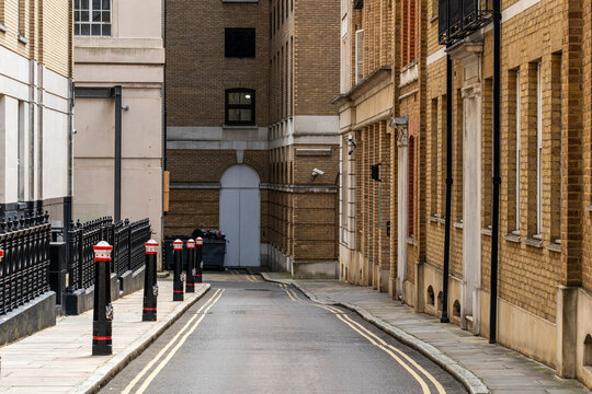 A quiet narrow alley between vintage brick buildings, representing the charm and nostalgia of an old city neighborhood. The scene is both peaceful and evocative of past eras  in London