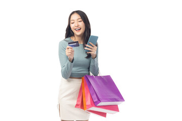 Young asian lady using mobile phone holding credit card carry shopping bags isolated over pastel green background and copy space Smiling young girl purchasing online through phone using credit card
