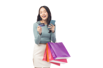 Young asian lady using mobile phone holding credit card carry shopping bags isolated over pastel green background and copy space Smiling young girl purchasing online through phone using credit card