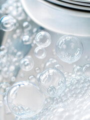 Looking down onto plates in a kitchen sink surrounded by soap bubbles