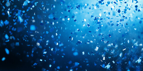 Blue confetti falling on a blue background with bokeh and copy space for design.