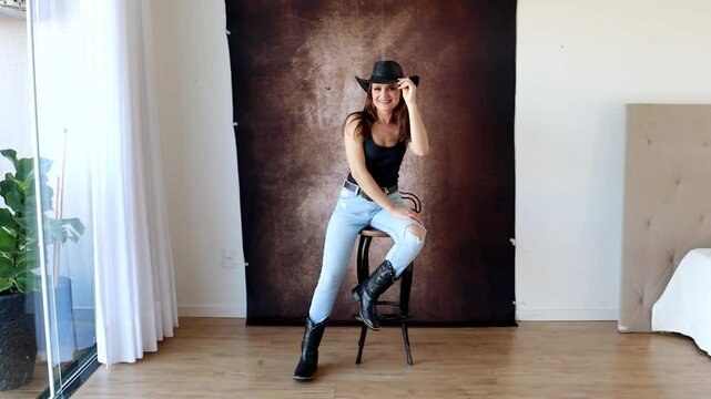 Mulher vaqueira usando chap&eacute;u faz poses para ensaio fotografico em est&uacute;dio