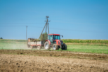 A tractor spreading manure on a field