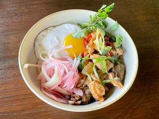 Grilled marinated chicken with white rice plater on a bowl, with seasoned chopped onion side dish, together With sunny sided egg and salad dressing. Fusion of asian and western cuisine.
