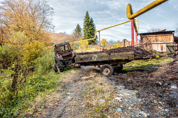 Fototapeta premium Rural landscape with tractor and trailer filled with manure