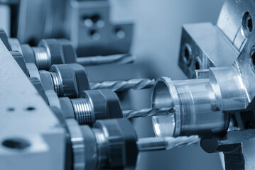 The multi- tasking CNC lathe machine swiss type drilling the metal shaft parts.