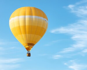 Naklejka premium A vibrant yellow hot air balloon floats gracefully against a bright blue sky with wispy white clouds.