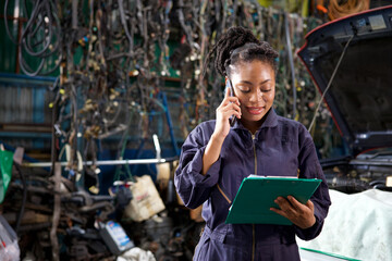 female worker or mechanic talking on smartphone with customer in garage