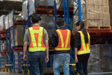 Obraz premium Male and female warehouse workers inspecting of product on shelf in storage warehouse. Group of warehouse workers discuss and training work in distribution branch