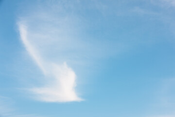 Light blue sky with a streaking white cloud, almost in the form of a dove in flight, over Lake Michigan at Harrington Beach State Park, Belgium, Wisconsin in January