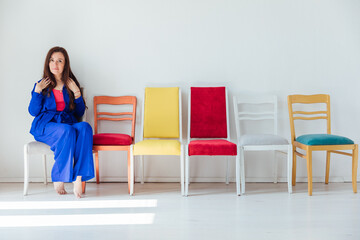 Fototapeta premium Woman in Blue Suit and Five Old Chairs