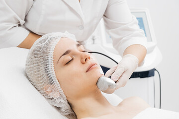 A cosmetologist performs RF lifting and ultrasound facial tightening in a modern salon. This advanced treatment rejuvenates and firms skin, perfect for showcasing effective beauty solutions.