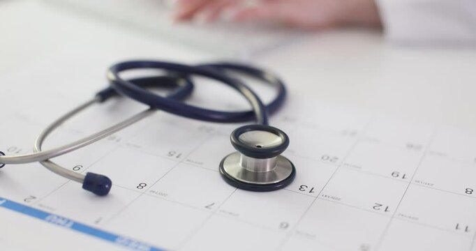 Stethoscope placed on printed calendar against doctor in hospital. Concept of time management vital for vaccination scheduling in healthcare industry