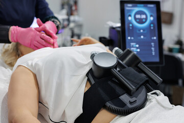 A woman is undergoing treatment to burn fat, build muscle and eliminate cellulite.