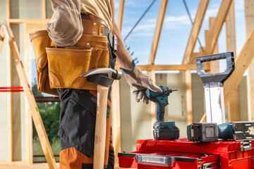 Construction Worker Preparing Tools at a Building Site on a Sunny Day in Early Summer