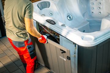 Technician Performing Maintenance on a Hot Tub in a Residential Backyard During Daytime