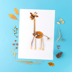 Kids autumn craft, giraffe made from a leaf. Large brown leaf with white spots for body, smaller...