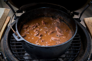 ready to eat - goulash from venison meat, from a roebuck -  cooked in a dutch oven on a charcoal grill at outdoor