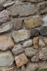 stone background from cobblestones brown and gray stone uneven close up