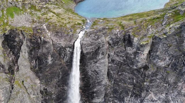 Epic waterfall in clouds zoom out drone shot, double waterfall of Mardalsfossen in Norway in 4K.