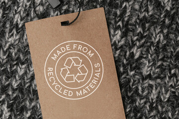 Close up of clothing tag with recycle icon. Recycling products concept. Zero waste, suistainale production, environment care and reuse concept.	