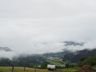 Paisaje de montañas con vegetación verde cubierta de niebla