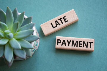 Late payment symbol. Concept word Late payment on wooden blocks. Beautiful grey green background...