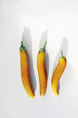 Three yellow eggplants of different shapes on a white background.