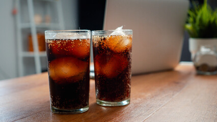 Double cool ice soft drink cola carbonated liquid fresh food with soda water, Cola drinking with ice in glass ready to refresh you, A cola soft drink is placed on the desk.