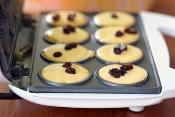 Waffles in the circular mold of a small electric waffle maker are easy to make yourself. Soft and selective focus.