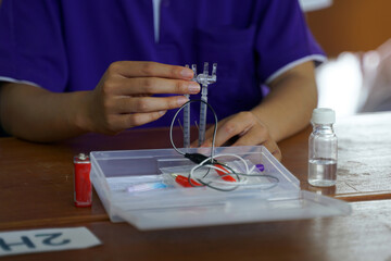 Asian school children conduct science experiments with kits Electrolysis, which is a method of electrically separating solutions to separate hydrogen and oxygen gases from water.