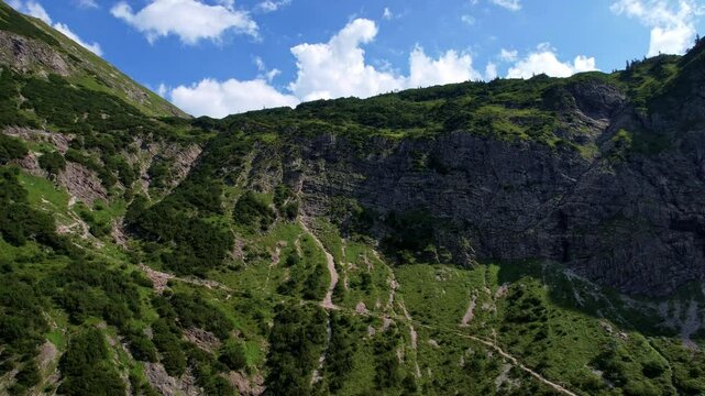 4K Aerial Drone video of the most beautiful mountain lake Schrecksee in Bavarian Alps with the cows feeding on lush green grass on a sunny day with blue skies and rocky hill tops surrounding