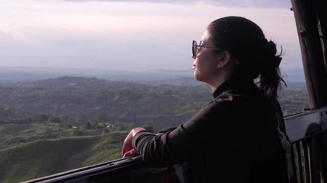 mujer disfrutando el atardecer, monta&ntilde;as del eje cafetero colombiano