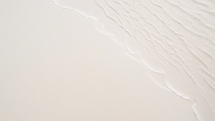 Fototapeta na wymiar top view of waves on the edge of a white sand beach with texture as a background.